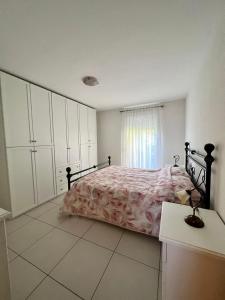 a bedroom with a bed and white cabinets and a window at Appartamento vacanze Sanzen - Como Cernobbio Lugano in Morbio Inferiore
