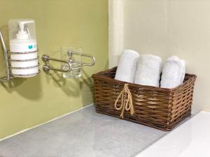 a basket of towels and a soap dispenser in a bathroom at Bosque Azul de Osa in Rancho Quemado