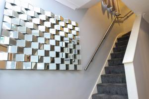 una escalera con un arte geométrico en la pared en The Grey Haven Birmingham, en Birmingham