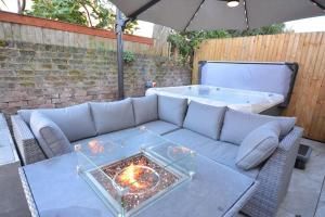 a couch and a table with an umbrella and a tub at Modern luxury home in Wallasey