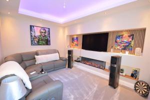 a living room with a couch and a flat screen tv at Modern luxury home in Wallasey