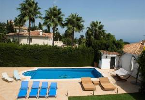 una piscina con tumbonas y sillas junto a una casa en Casa Kasima for family gatherings, en Cabopino