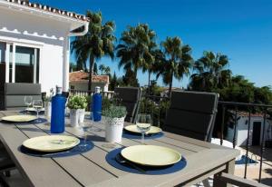 Una mesa con platos y copas de vino en un patio. en Casa Kasima for family gatherings, en Cabopino