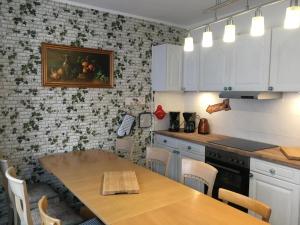 a kitchen with white cabinets and a table with chairs at Haus am Fluss mit wunderschöner Dachterrasse mit Flussblick ,Garten und Grill in Zorge