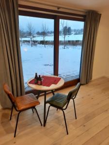 einen Tisch und zwei Stühle vor einem Fenster in der Unterkunft Le Grand Ravel in Weismes