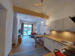 een keuken en een woonkamer met een tafel en een bank bij Boutique-Apartments Seminarium F5 Fieberbrunn in Fieberbrunn