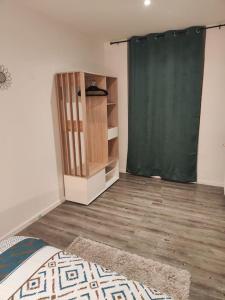a room with a green curtain and a wooden floor at Appartement spacieux, hyper centre avec parking in Saint-Étienne