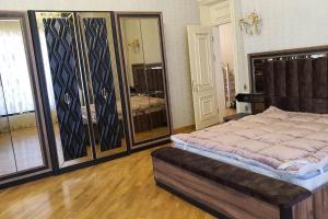 巴庫的住宿－Buzovna Villa，一间卧室设有一张大床和一个大镜子