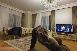 a living room with a couch and a flat screen tv at Buzovna Villa in Baku