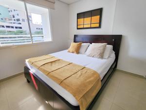 a bedroom with a large bed with white sheets and a window at Apartamentos con vista al mar Brisa Marina Rodadero - by Bedviajes in Santa Marta +47 photos