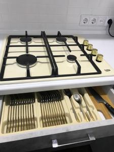 a stove top in a kitchen with some utensils at Люкс в центре Караганды in Karagandy +19 photos
