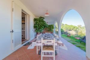 a long table in a room with an archway at La Palazzina nel Verde - Goelba in Campo nell'Elba