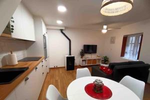 a kitchen and living room with a white table and chairs at A casiña de Luz in Pontevedra