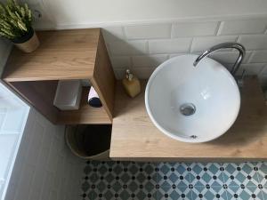 a bathroom with a white sink and a wooden counter at A casiña de Luz in Pontevedra