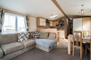 a living room with a couch and a kitchen at Lyons Retreat in Lossiemouth