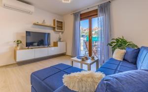 een woonkamer met een blauwe bank en een tv bij Apartment Blue Pula, New, Family friendly, Comfortable, free parking and WiFi in Pula
