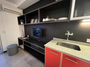 eine Küche mit einem Waschbecken und einer schwarzen Wand in der Unterkunft Departamento en Castelar in Castelar