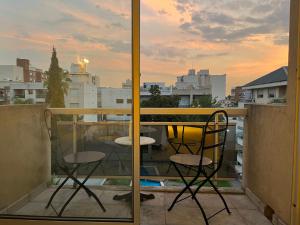 a balcony with two chairs and a view of a city at Departamento en Castelar in Castelar