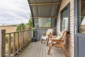 a porch with two chairs on a house at Beautiful bolt hole for 2 with breathtaking views in Kingsbridge