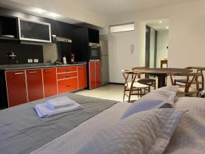 ein Schlafzimmer mit einem Bett und eine Küche mit einem Tisch in der Unterkunft Departamento en Castelar in Castelar