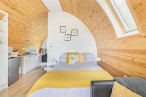 a bedroom with a bed in a room with wooden walls at Beautiful bolt hole for 2 with breathtaking views in Kingsbridge