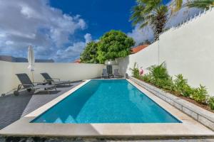 a swimming pool in the backyard of a house at Beach Dream Island House in Oranjestad