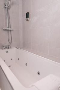 利物浦的住宿－Phoenix Hotel Liverpool，带淋浴的浴室配有白色浴缸。