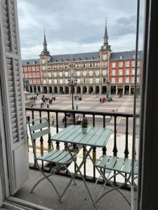 una mesa y sillas frente a un gran edificio en Plaza Mayor, en Madrid