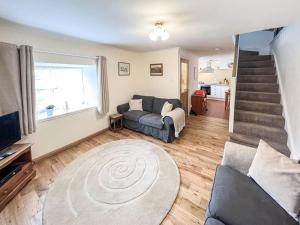 sala de estar con sofá y escalera en Willesdene Cottage en Abernethy