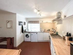 a kitchen with a sink and a washing machine at Willesdene Cottage in Abernethy