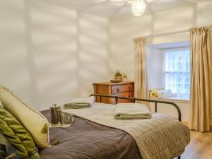 Schlafzimmer mit einem Bett und einem Fenster in der Unterkunft Willesdene Cottage in Abernethy