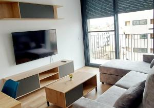 ein Wohnzimmer mit einem Sofa und einem großen TV in der Unterkunft Palma centro in Palma de Mallorca