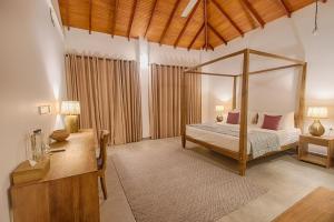 een slaapkamer met een hemelbed en een bureau bij Gracian Villa in Kandy