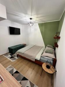 a bedroom with a bed and a table and a tv at Guest House Time Out in Sarajevo