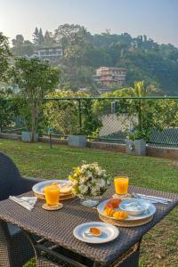 een tafel met borden eten en sinaasappelsap bij Gracian Villa in Kandy