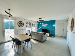 een woonkamer met een tafel en een bank bij L'océan, T3 neuf 300m de la mer classé 3 étoiles in Saint-Jean-de-Monts
