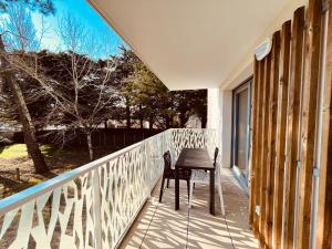 einen Stuhl auf einer Veranda mit einem Fenster in der Unterkunft L'océan, T3 neuf 300m de la mer classé 3 étoiles in Saint-Jean-de-Monts