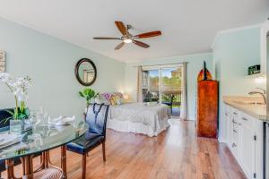 a living room with a table and a bed at Sandpiper #105b in Princeville