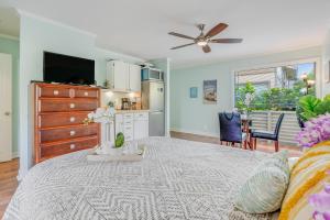 a bedroom with a large bed and a kitchen at Sandpiper #105b in Princeville