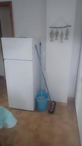 een kamer met een bezem en een koelkast in een kamer bij Petite maison ploufragan in Ploufragan