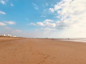 eine Gruppe von Menschen, die am Strand spazieren gehen in der Unterkunft L'océan, T3 neuf 300m de la mer classé 3 étoiles in Saint-Jean-de-Monts + 6 Fotos