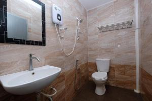 a bathroom with a toilet and a sink and a shower at Q Hotel Temerloh in Temerloh