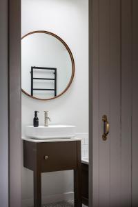 a bathroom with a sink and a mirror on the wall at Linseed Barn- Stamford Holiday Cottages in Stamford
