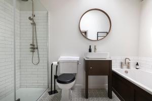 a bathroom with a toilet and a sink and a mirror at Linseed Barn- Stamford Holiday Cottages in Stamford +21 photos