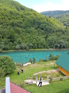 a group of people standing next to a lake at Motel Bavaria in Foča
