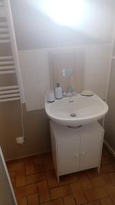 een badkamer met een witte wastafel in een kamer bij Petite maison ploufragan in Ploufragan