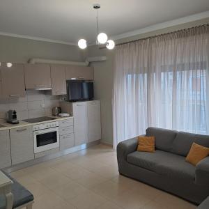 a living room with a couch and a kitchen at Lefkada CP Residences in Lefkada Town