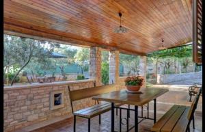 a patio with a table and chairs and a fireplace at MANDULERA in Peroj