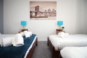 a room with two beds and a painting on the wall at Modern 2 Bedroom Flat in Robert st, Swansea in Swansea