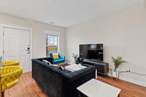 a living room with a black couch and a tv at Stylish and Comfortable 1-BR in the Heart of Detroit in Detroit
